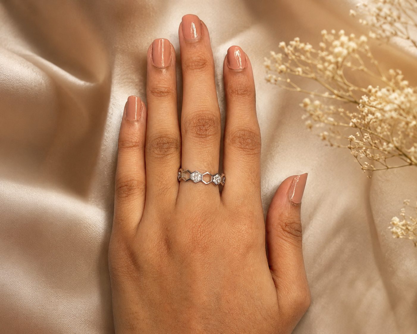 Honeycomb ring crafted from silver-plated material and features sparkling cubic zirconia stones in an adjustable design