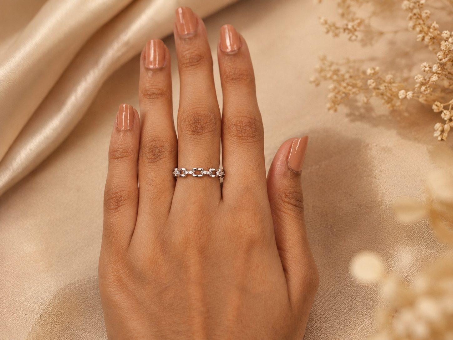 Features interlocking links styled as a chain with pavé-set stones.
