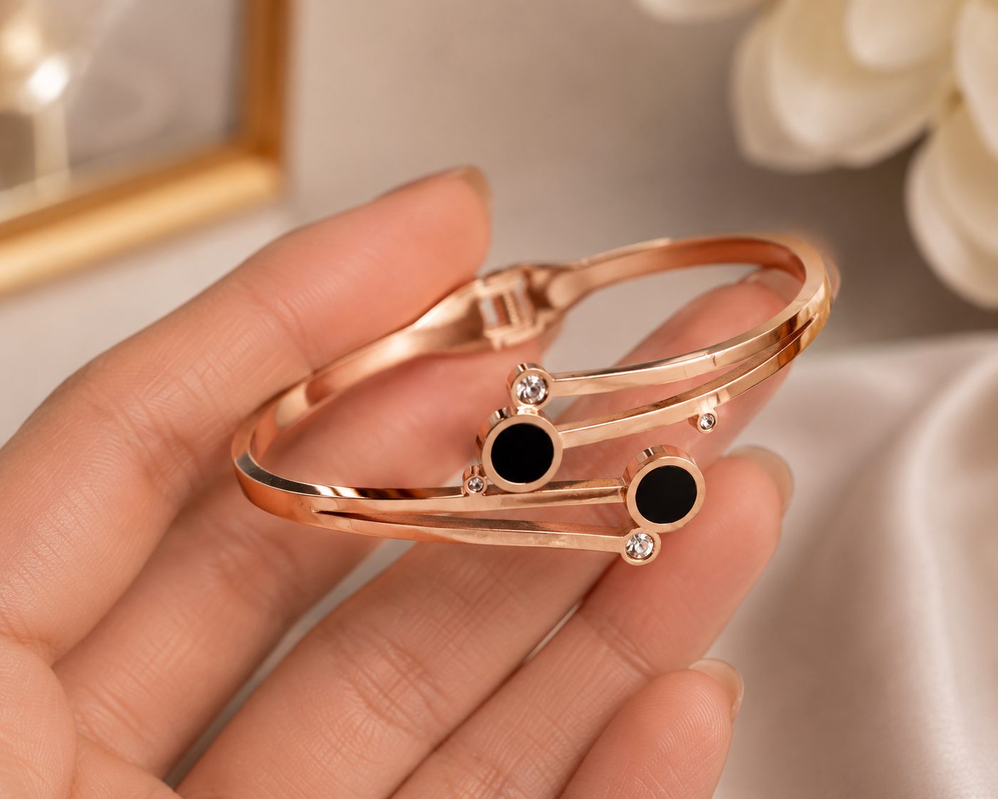 Rose gold bracelet features a modern, geometric design with distinctive black circular accents.