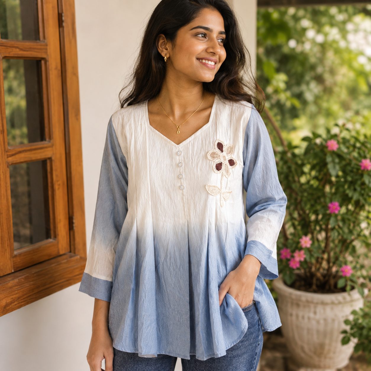 tunic with a v-neckline, three-quarter sleeves, and delicate floral applique embroidery on the chest.